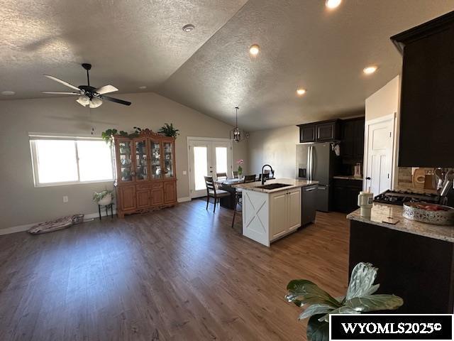 109 Chardonnay, Rock Springs, WY 82901 - kitchen with stainless steel fridge, a sink, an island with sink, a ceiling fan, and vaulted ceiling
