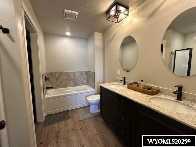 109 Chardonnay, Rock Springs, WY 82901 - full bath with toilet, a sink, a garden tub, and wood finished floors