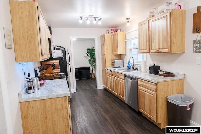 kitchen featuring light brown cabinetry, a sink, light countertops, stainless steel dishwasher, and dark wood-style floors