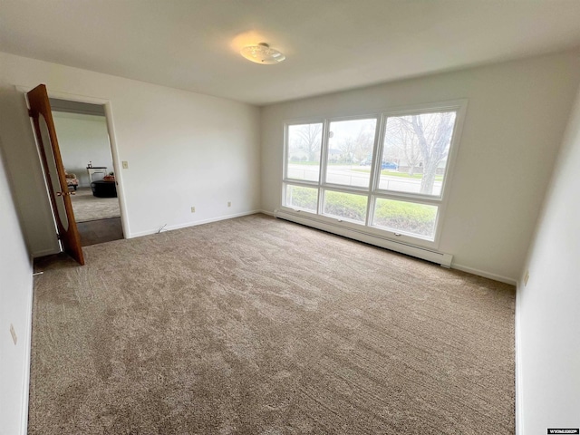 empty room with carpet flooring, baseboards, and a baseboard heating unit