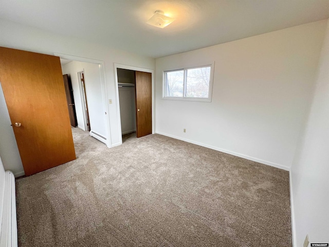 unfurnished bedroom featuring a closet, baseboards, carpet floors, and a baseboard heating unit