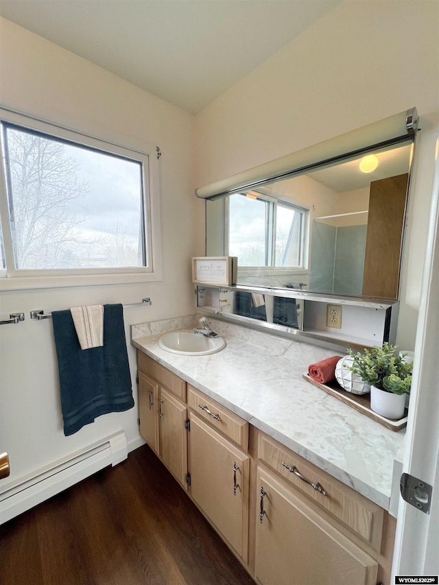 bathroom featuring vanity, wood finished floors, and a baseboard radiator