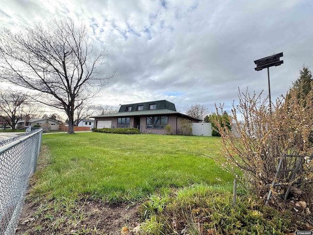 view of yard featuring fence and an attached garage