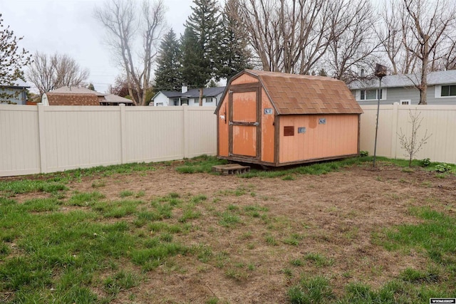 view of yard featuring an outbuilding, a fenced backyard, and a shed