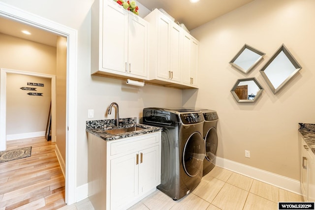 88 Turnberry Dr, Sheridan, WY 82801 - washroom with baseboards, a sink, cabinet space, and washing machine and clothes dryer