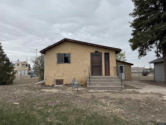 124 Railroad St, Lingle, WY 82223 - rear view of house featuring entry steps and stucco siding