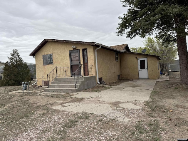 124 Railroad St, Lingle, WY 82223 - rear view of house featuring stucco siding