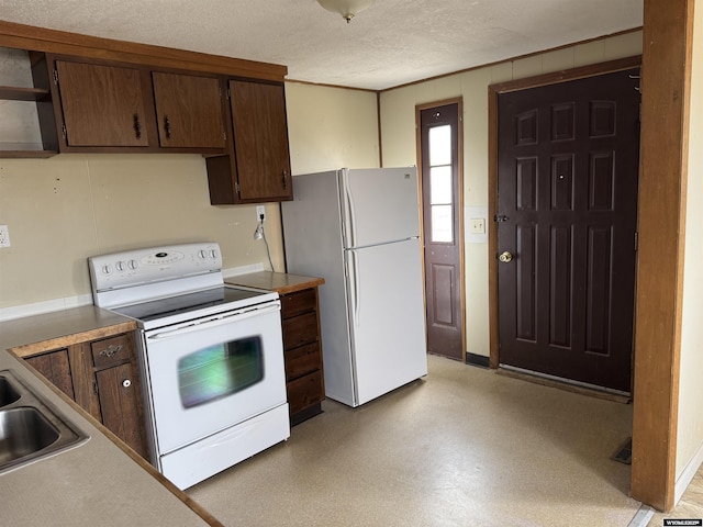124 Railroad St, Lingle, WY 82223 - kitchen featuring white appliances, a textured ceiling, a sink, and light countertops