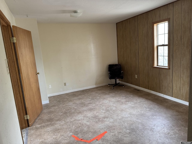 124 Railroad St, Lingle, WY 82223 - empty room featuring baseboards, wood walls, and carpet