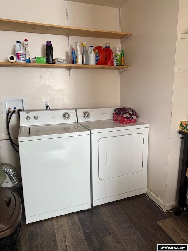 clothes washing area featuring laundry area, dark wood finished floors, and washer and clothes dryer