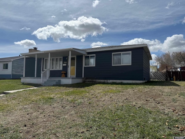 manufactured / mobile home with covered porch, fence, and a front lawn