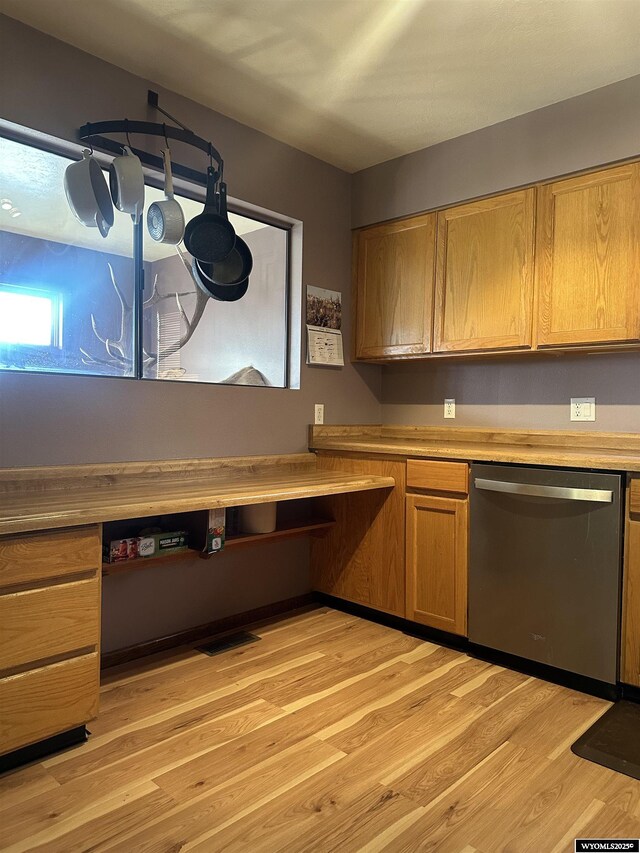 kitchen featuring stainless steel dishwasher, visible vents, built in study area, light wood-style floors, and brown cabinets