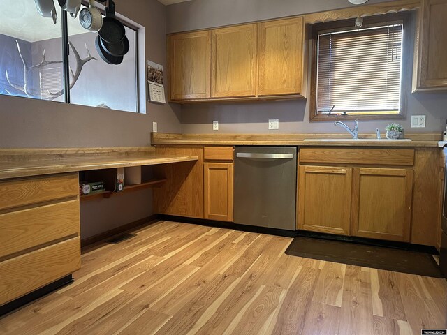 kitchen featuring light countertops, brown cabinets, a sink, light wood-style flooring, and dishwasher