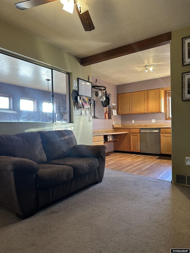 living room with visible vents, beam ceiling, light carpet, ceiling fan, and light wood-type flooring