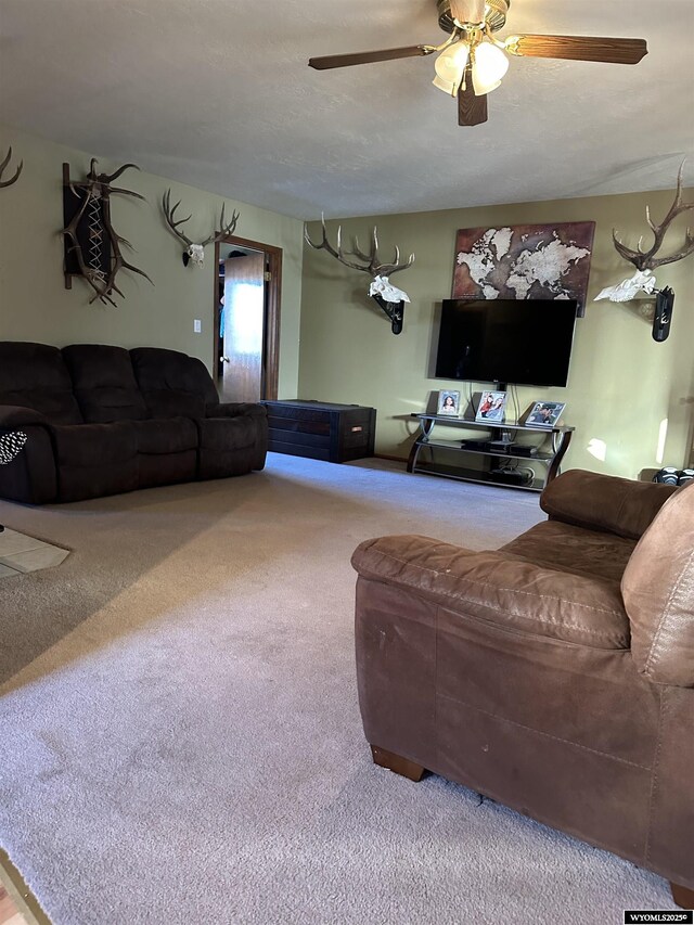 carpeted living area featuring ceiling fan