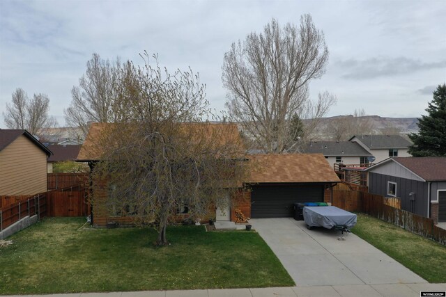 view of front of property featuring driveway, a front yard, and a garage