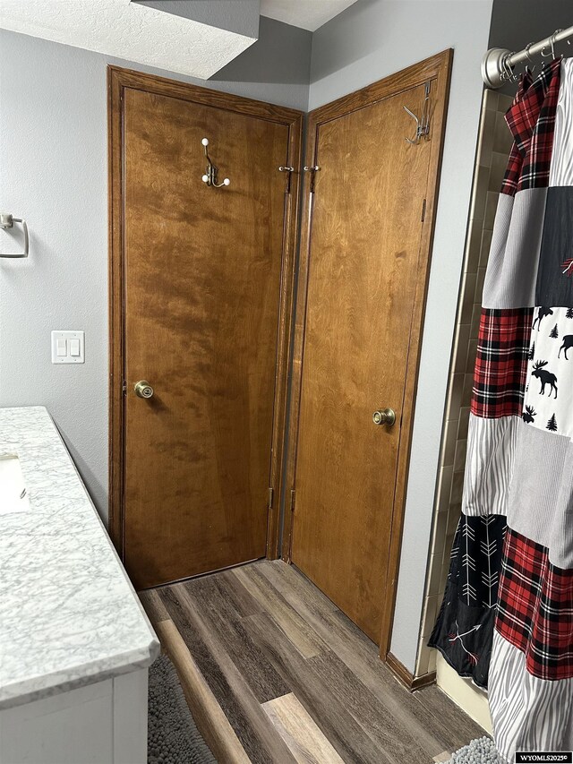 full bathroom with vanity, curtained shower, and wood finished floors