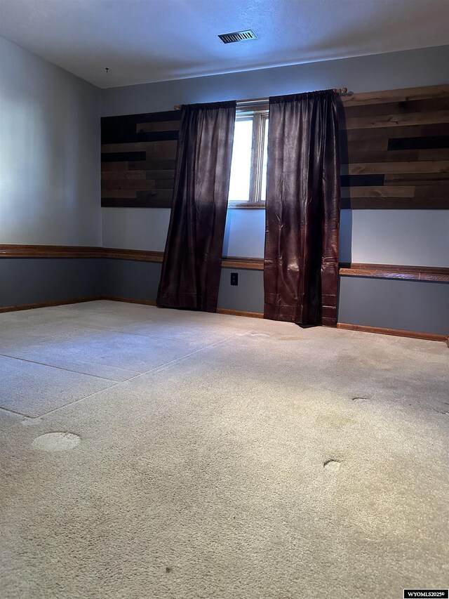 empty room with carpet floors and visible vents