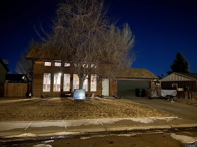 view of front facade featuring an attached garage, fence, and driveway