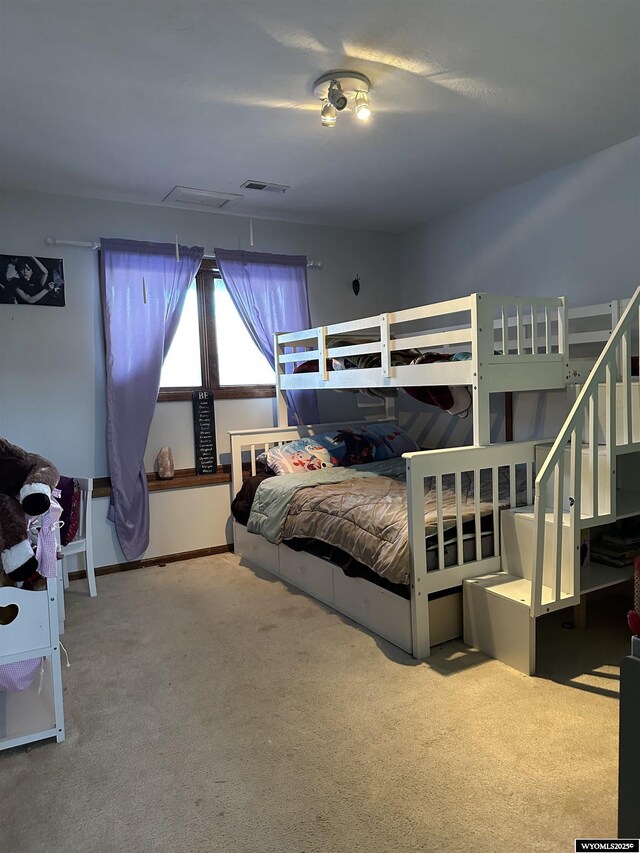 carpeted bedroom featuring visible vents
