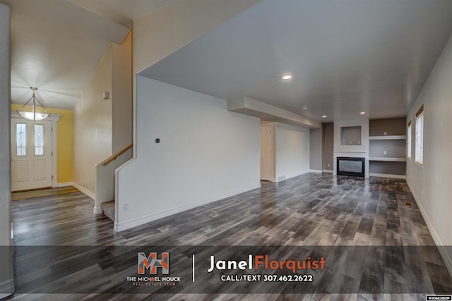 3507 Aspen Ln, Casper, WY 82604 - unfurnished living room featuring a healthy amount of sunlight, stairway, a glass covered fireplace, and wood finished floors