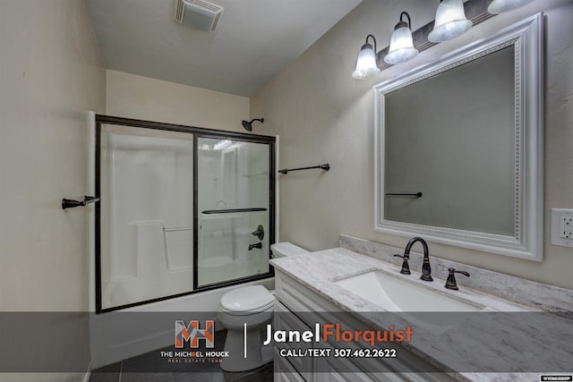 bathroom featuring toilet, visible vents, combined bath / shower with glass door, and vanity