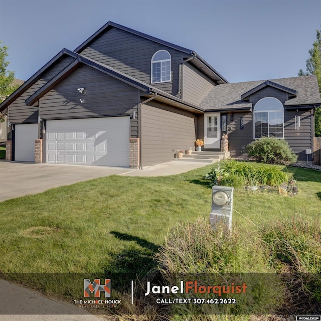 traditional-style house featuring a garage, a shingled roof, concrete driveway, and a front yard