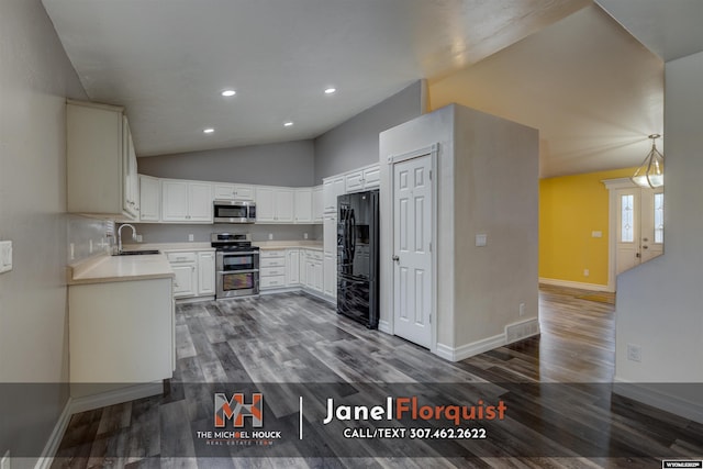 kitchen with lofted ceiling, light countertops, a sink, dark wood finished floors, and appliances with stainless steel finishes