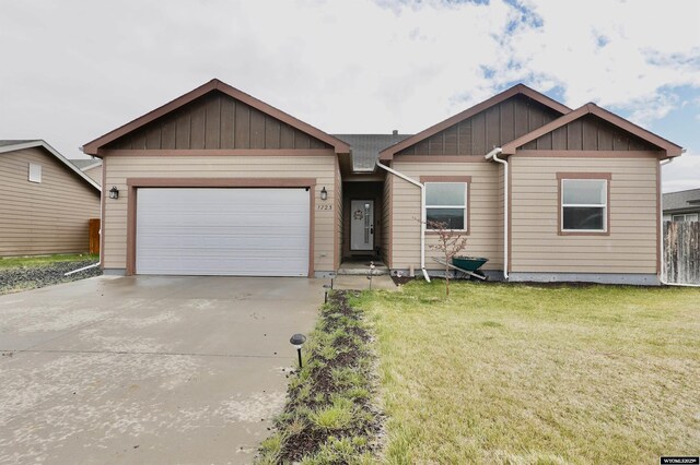 ranch-style home with board and batten siding, a garage, driveway, and a front lawn