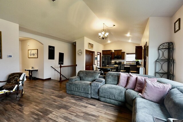 living area with an inviting chandelier, arched walkways, dark wood finished floors, and lofted ceiling