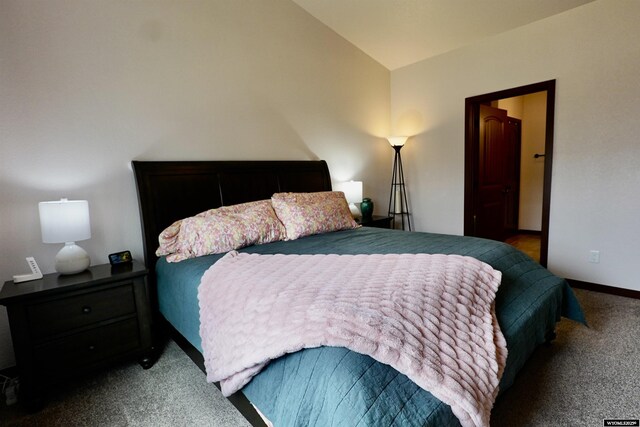 carpeted bedroom with baseboards and lofted ceiling