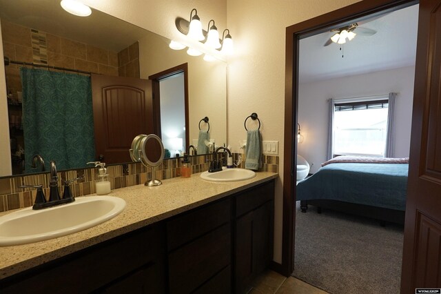 bathroom with a sink, backsplash, and double vanity