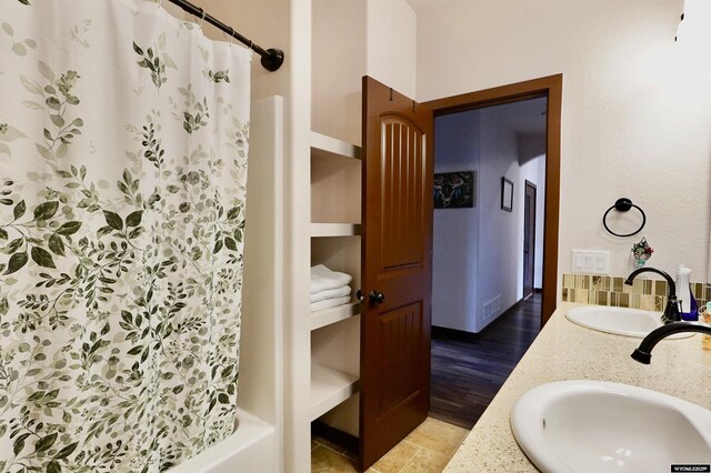 bathroom with visible vents, a sink, and double vanity