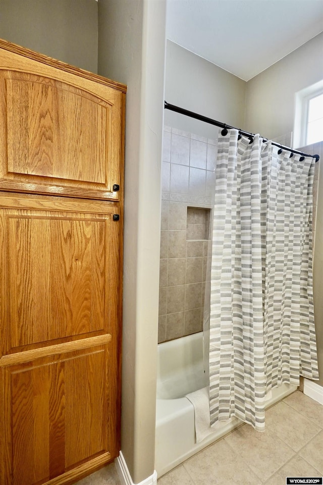 full bath featuring baseboards, tile patterned floors, and shower / bath combo