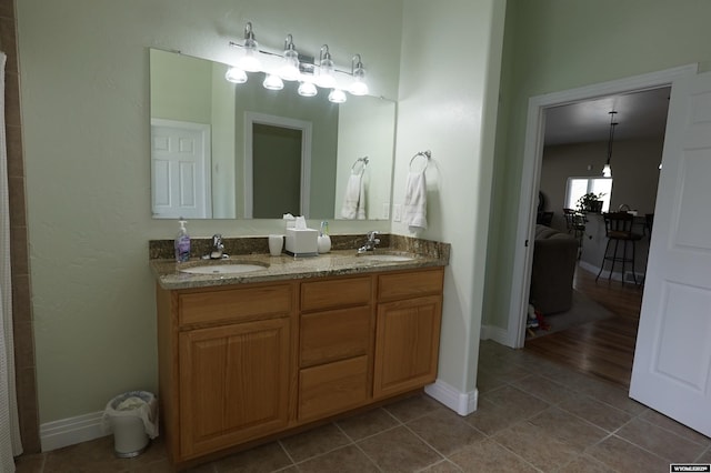 full bath with tile patterned flooring, a sink, and baseboards
