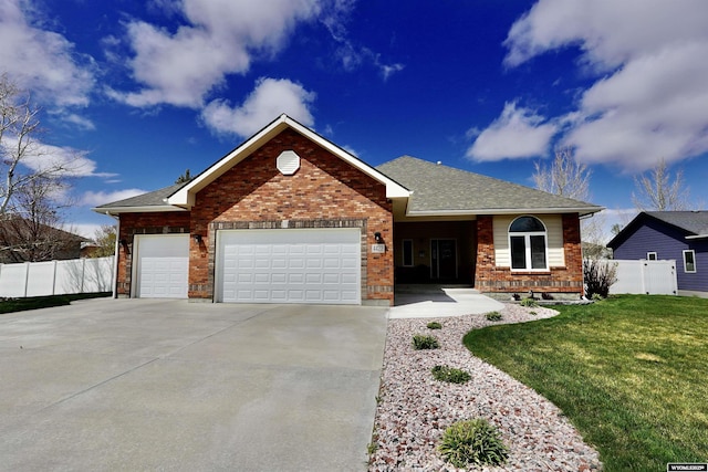 ranch-style house featuring a front yard, brick siding, fence, concrete driveway, and an attached garage