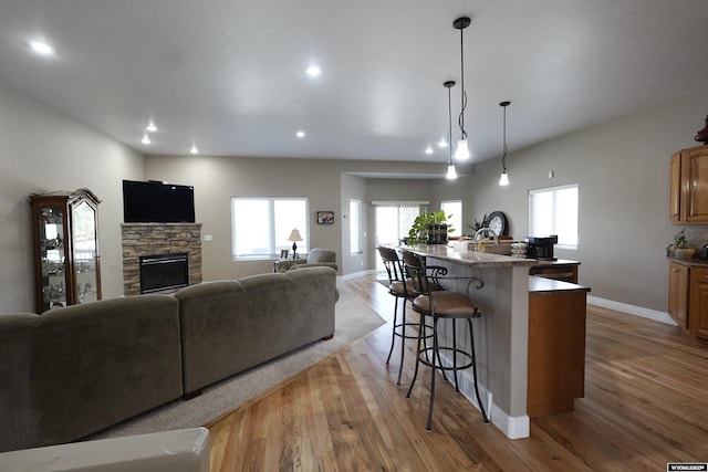 living area with baseboards, light wood-type flooring, and a wealth of natural light