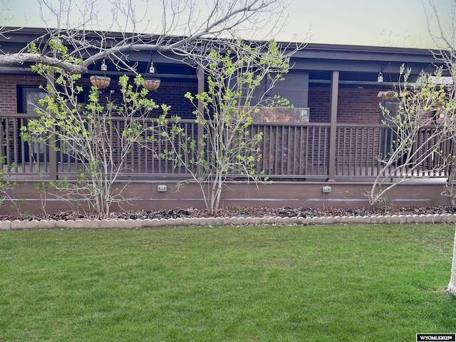 view of side of property featuring a yard and brick siding
