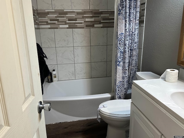 bathroom featuring wood finished floors, shower / tub combo, vanity, toilet, and a textured wall