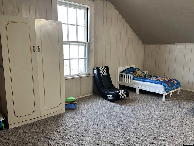 bedroom featuring carpet floors, wood walls, and multiple windows