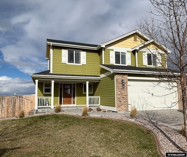 999 Eagle Dr, Douglas, WY 82633 - view of front facade with a garage, concrete driveway, brick siding, and a porch