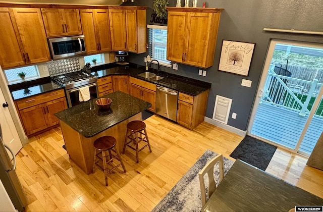 999 Eagle Dr, Douglas, WY 82633 - kitchen with stainless steel appliances, a sink, brown cabinets, and light wood-style floors
