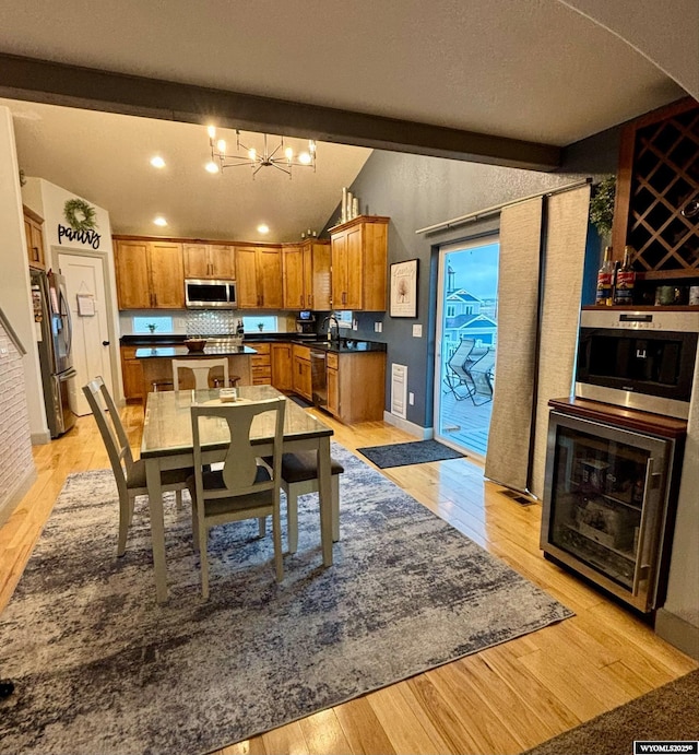 999 Eagle Dr, Douglas, WY 82633 - kitchen with stainless steel appliances, brown cabinets, a chandelier, light wood-style flooring, and recessed lighting