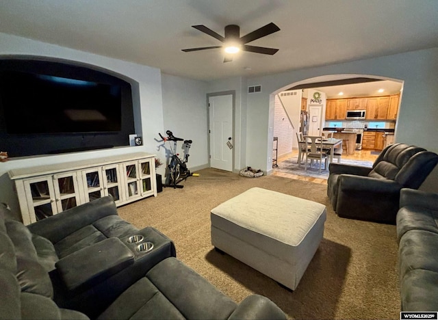 999 Eagle Dr, Douglas, WY 82633 - living area with arched walkways, light colored carpet, a ceiling fan, and baseboards