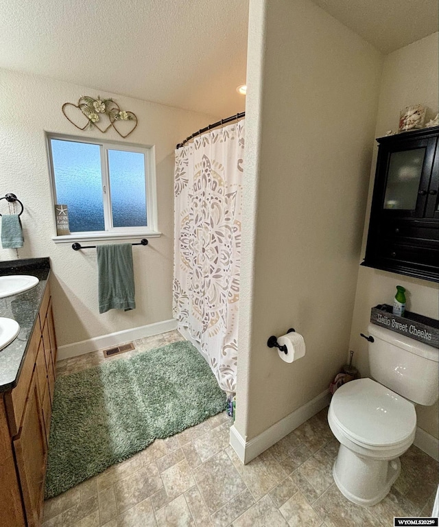 999 Eagle Dr, Douglas, WY 82633 - full bathroom featuring toilet, a textured ceiling, vanity, baseboards, and a shower with curtain