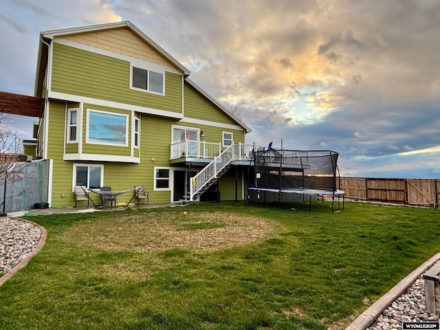 999 Eagle Dr, Douglas, WY 82633 - back of property featuring stairway, a trampoline, and a deck