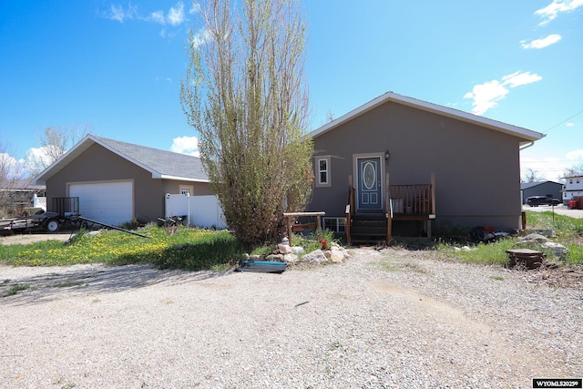 view of front of house with a garage, stucco siding, and fence