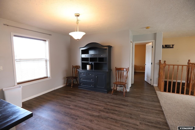 dining area featuring baseboards, a textured ceiling, and dark wood-style floors