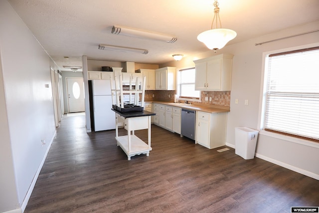kitchen with freestanding refrigerator, decorative backsplash, white cabinetry, a sink, and dishwasher