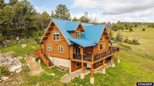 18 High Meadows Rd, Buffalo, WY 82834 - rear view of house featuring fence, log siding, a deck, a lawn, and metal roof